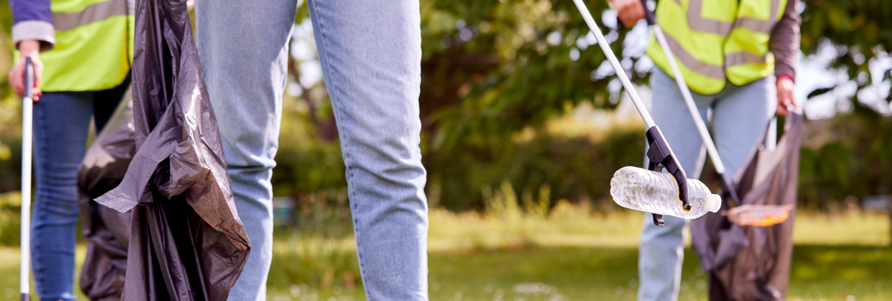 People using garbage pickers and garbage bags to pick up litter