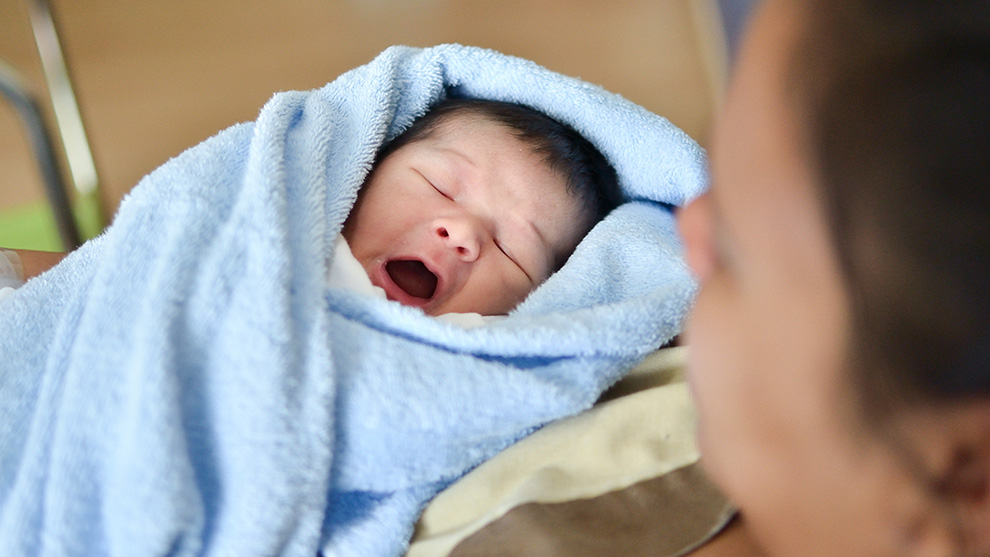infant in a blue blanket