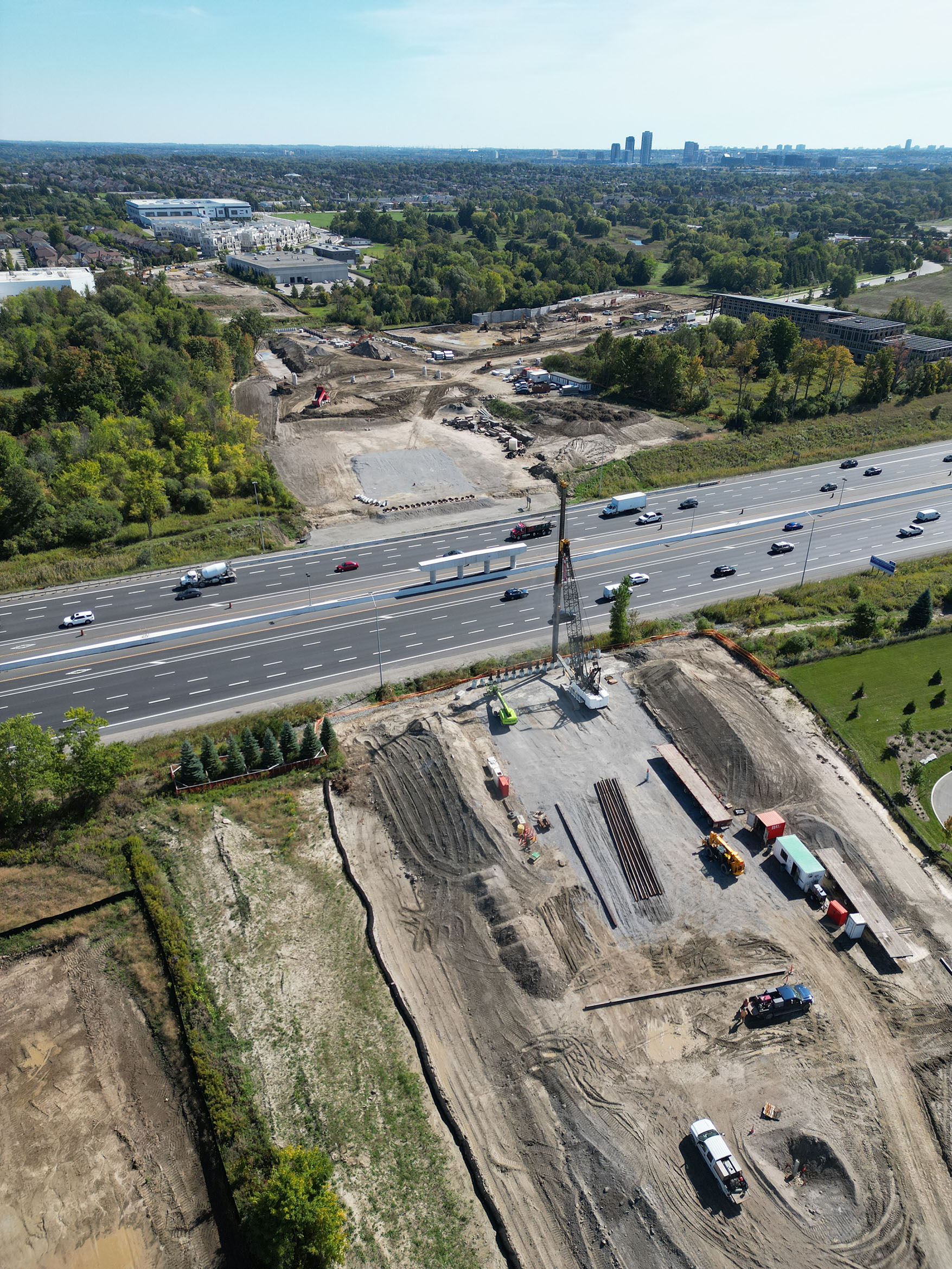 Machines bore holes for pipes that create a foundation to support the new road crossing