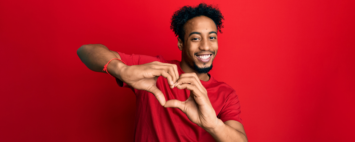 Young adult holding their hands together in the shape of a heart
