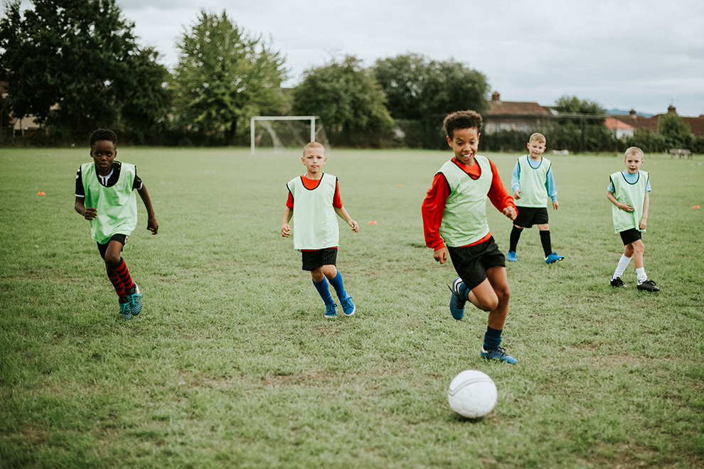 Children playing soccer in a field