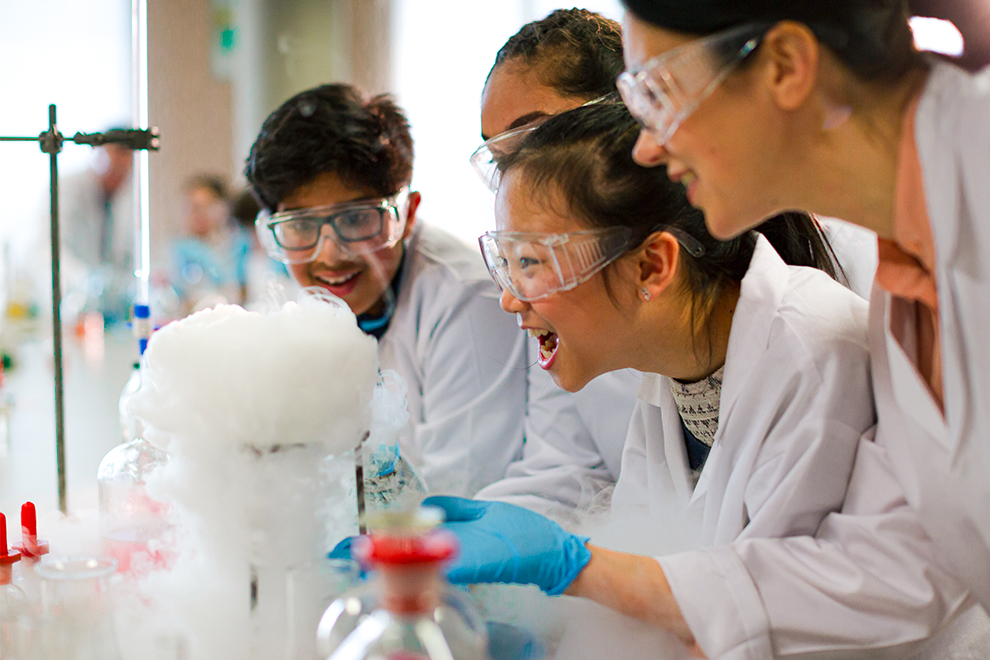 students wearing safety glasses performing experiments in a lab