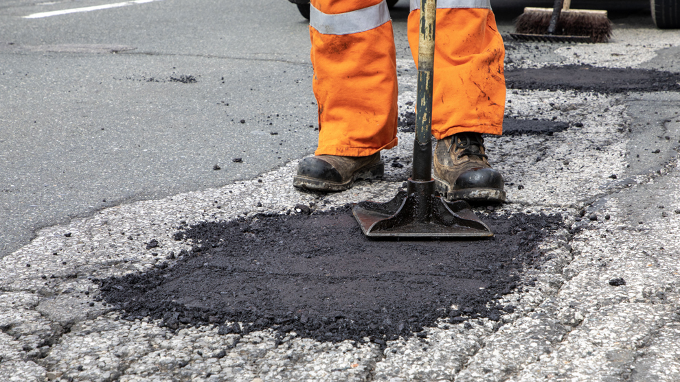 pothole on the road being fixed with new asphalt