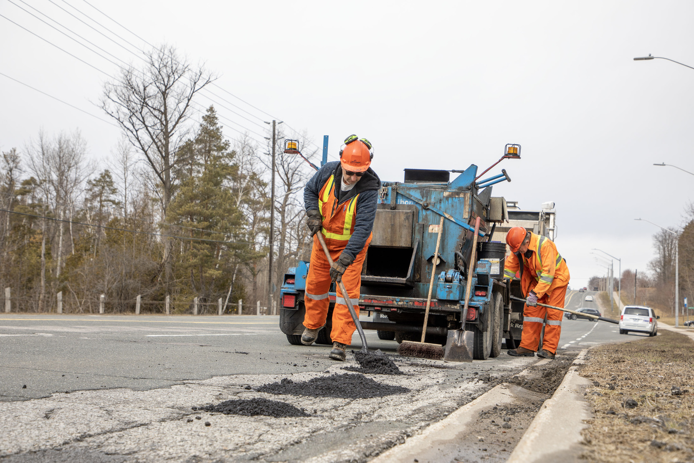 York region staff filling pot hole on road