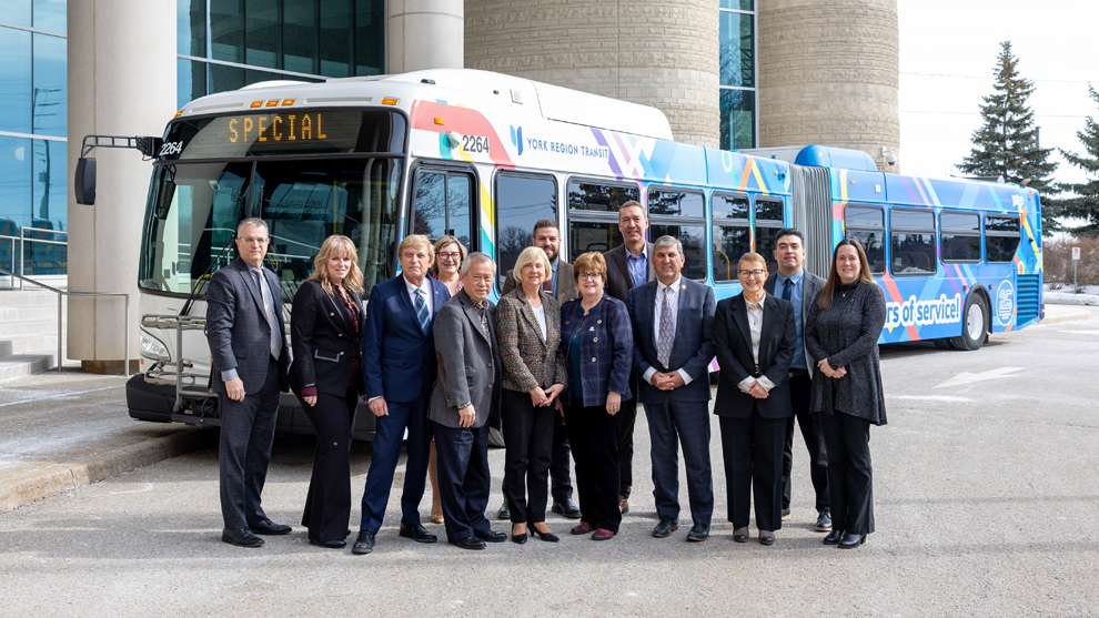 council members standing in front of the YRT 25th anniversary wrapped bus at the York Region Administrative Centre in Newmarket