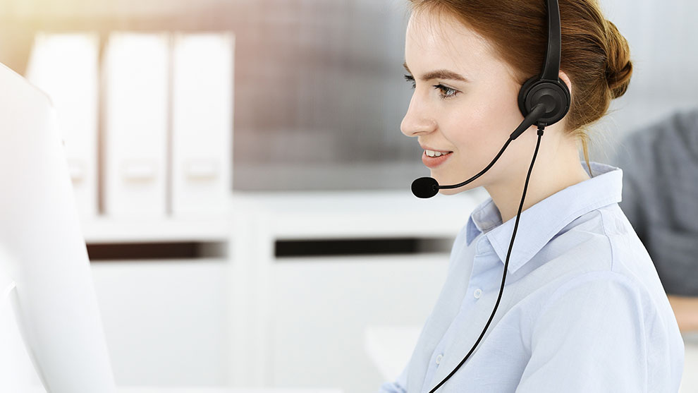 person with headset in front of computer