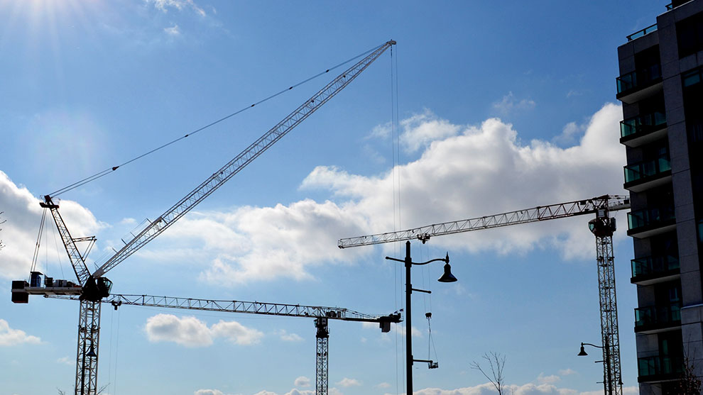 Tall construction cranes in the sky