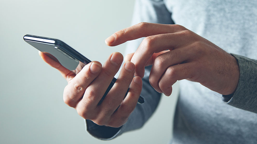 Close up image of a person's hands holding a smart phone