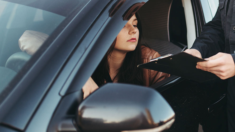 female driver looking at officer clipboard