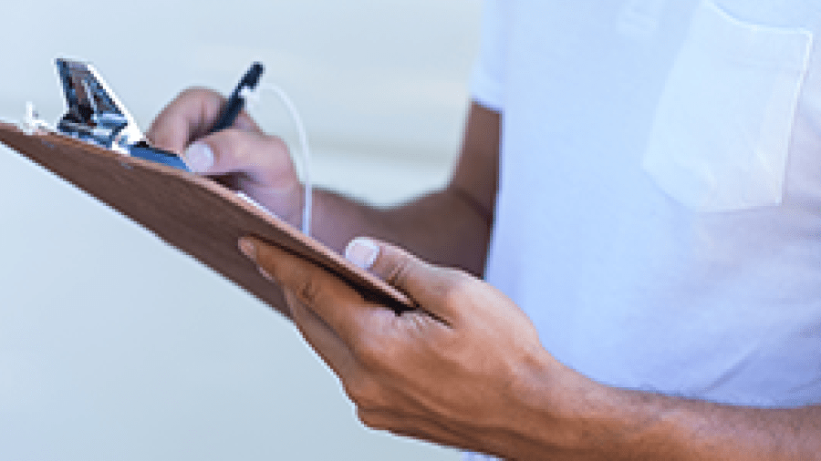 A man making notes on a clipboard