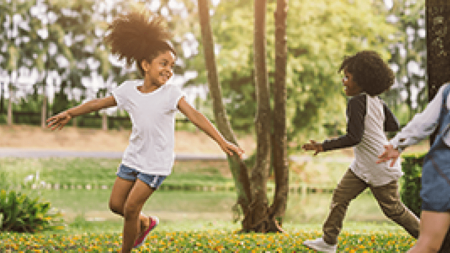 Children running around a tree, playing a game together