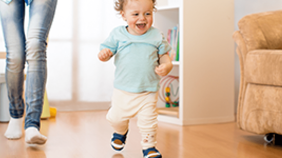 A toddler running in the house followed by his mother