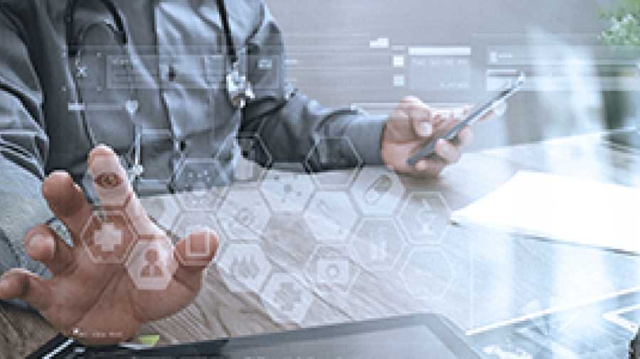 A doctor at a desk touching an electronic screen in front of him