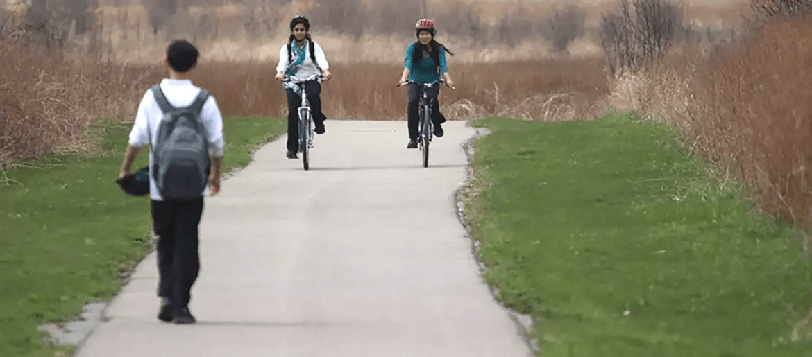 People traveling by bike and foot along pathway