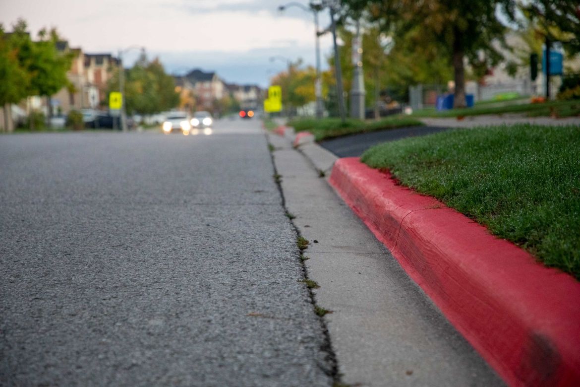 Image of a red line painted on a sidewalk curb