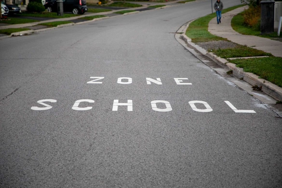 Image of the marking "School Zone" painted on a road pavement