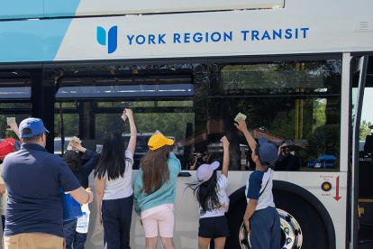 York Region Transit bus parked with people standing outside of it.