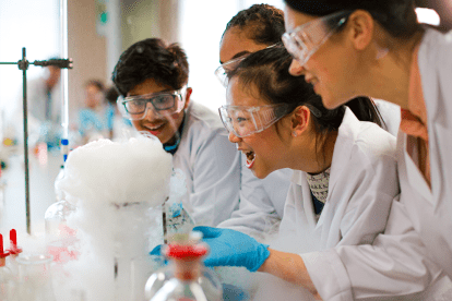 students wearing safety glasses performing experiments in a lab