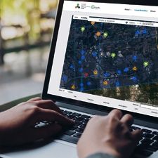 a person sitting at a computer looking at reuse hub locations on a map