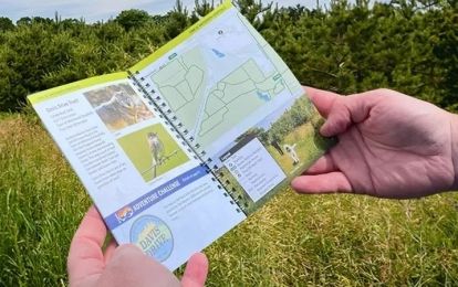 Holding Everyday Guide on a trial in the York Regional Forest