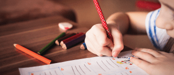 child drawing with coloured pencils