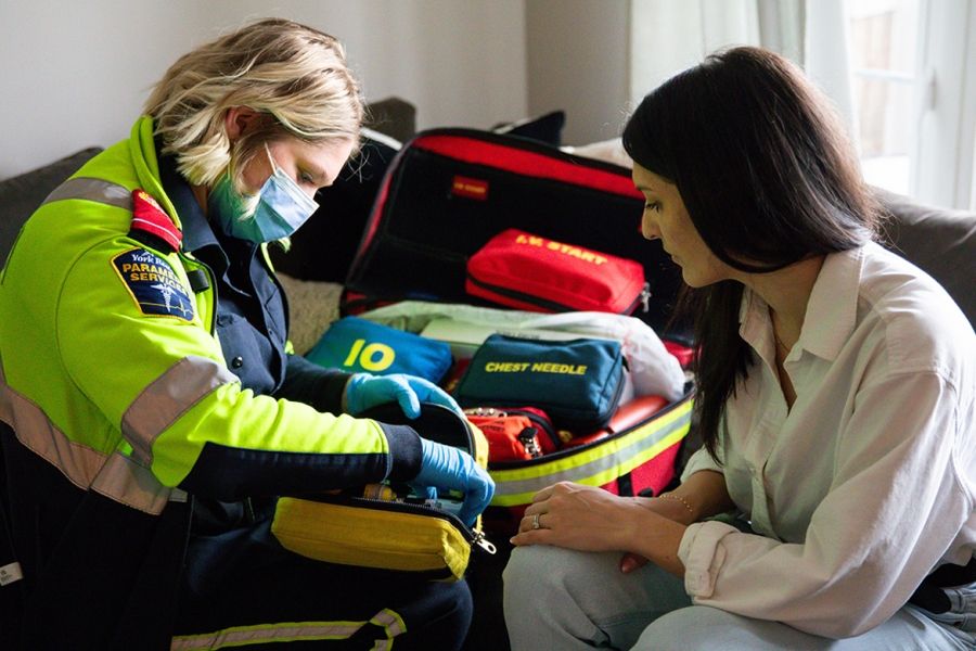 Paramedic attending to a patient in their home