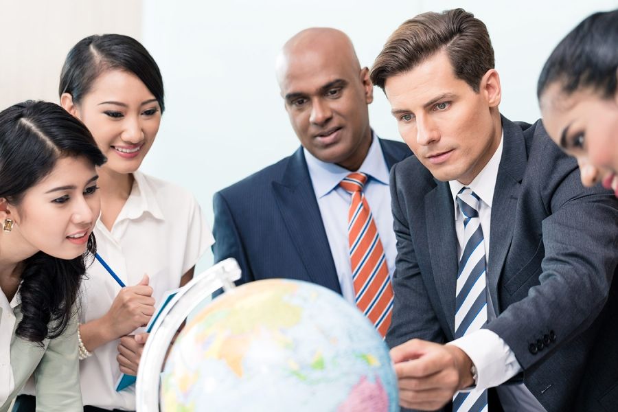 Team of international employees around a globe