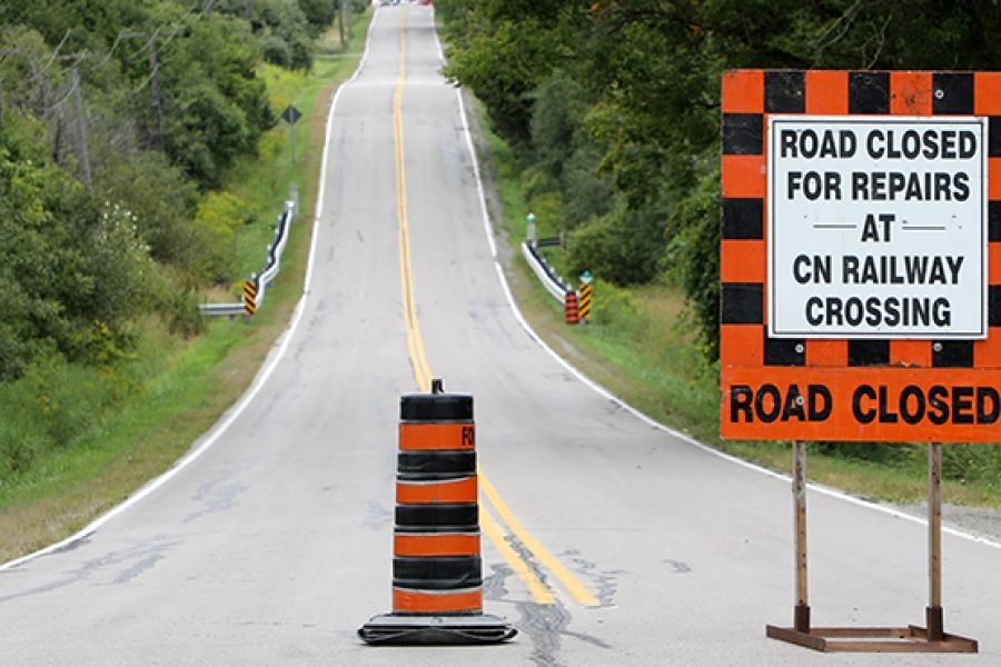 Image of notice sign in the middle of road with the sign reading "Road Closed"