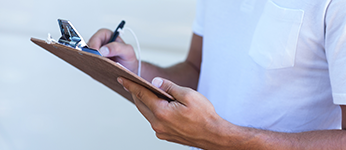 A man making notes on a clipboard
