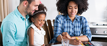 A family doing a craft while sitting at the kitchen table
