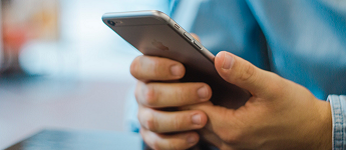 Close up image of a person's hands holding a smart phone